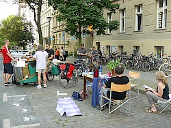 Tisch mit Stühlen daneben ein Lastenrad